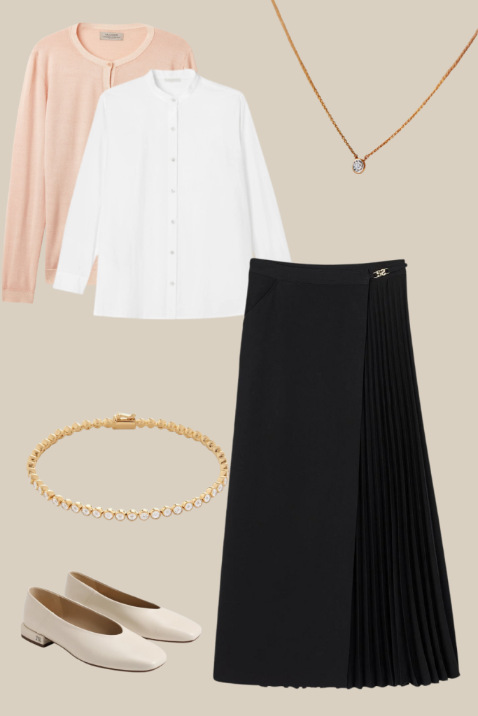 Classic Thanksgiving outfit featuring a soft peach cardigan, crisp white button-up blouse, black pleated midi skirt, delicate gold necklace, pearl bracelet, and cream ballet flats. A feminine, timeless ensemble ideal for a graceful holiday gathering.