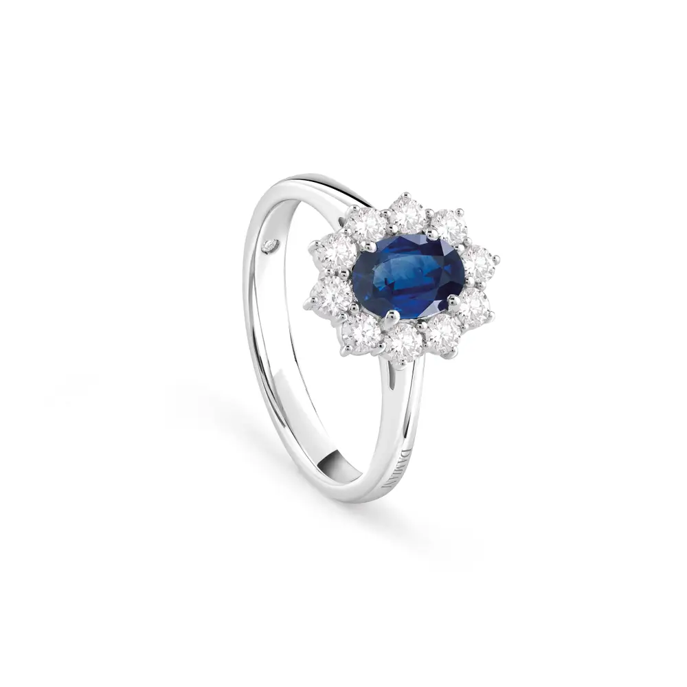 Sophisticated blue sapphire halo ring worn on hand, with a deep blue center stone framed by sparkling diamonds, perfect for a refined, vintage-inspired look.
