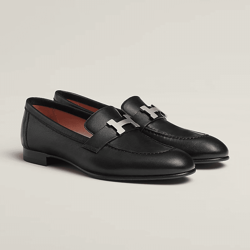 Black leather loafers with silver buckle detail, classic flat style associated with timeless old money shoe brands