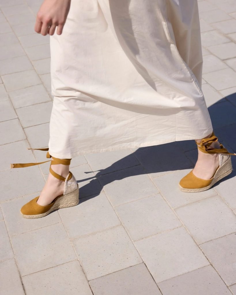 Camel espadrille flats worn with flowing skirt, understated summer footwear from old money shoe brands