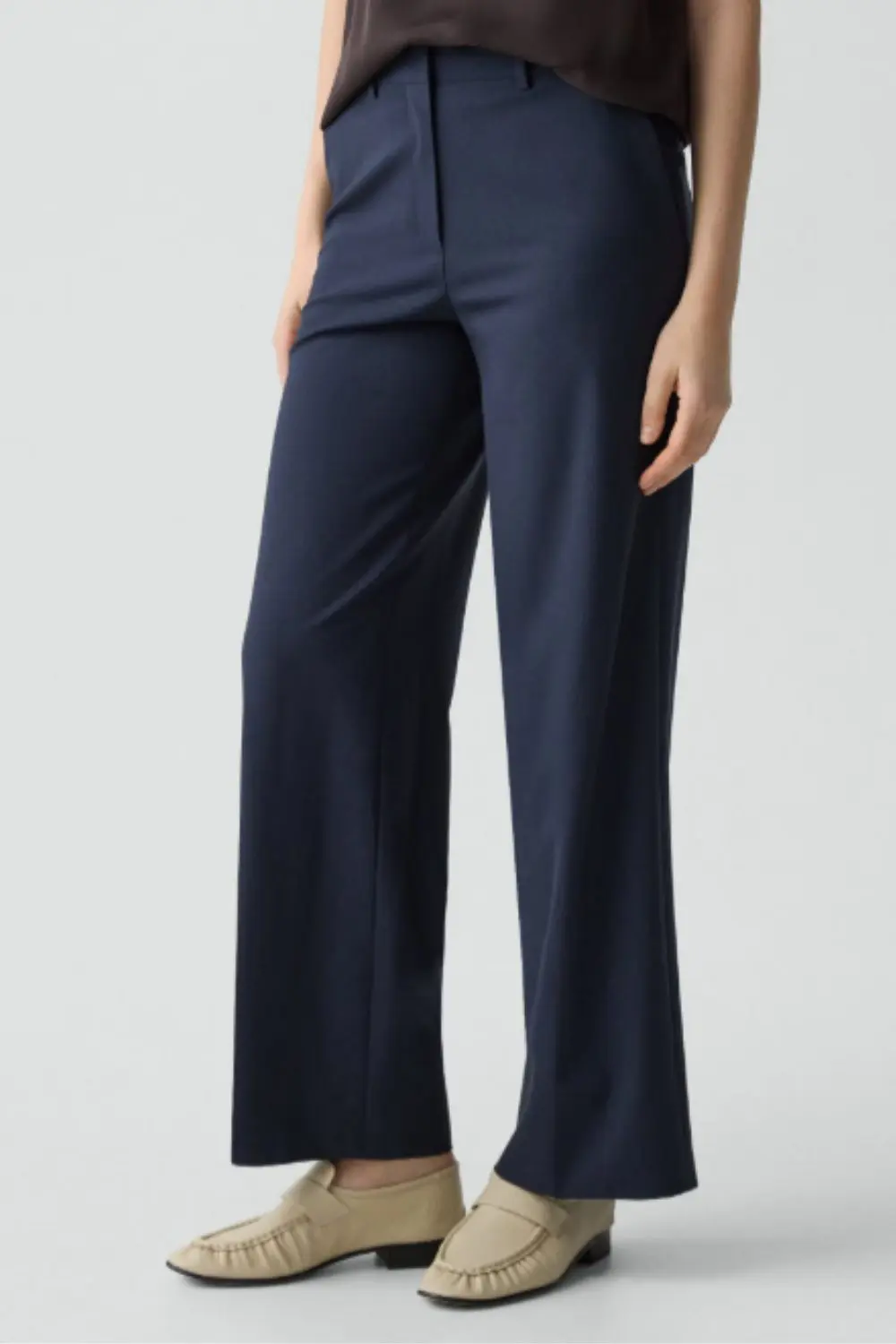Tailored navy trousers styled with neutral loafers, a refined base layer from 7 Timeless Pieces to Start 2026 Right