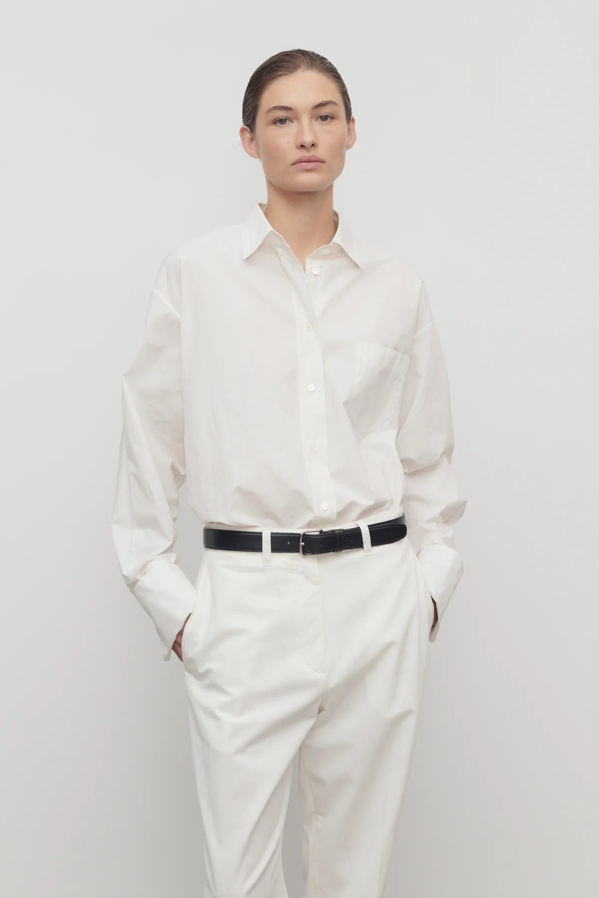 Crisp white button-down shirt styled with tailored trousers, a classic staple for Capsule Wardrobe 2026 with clean, effortless elegance