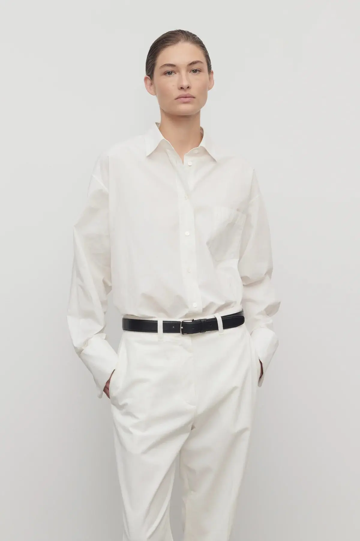 Crisp white button-down shirt styled with tailored trousers, a classic staple for Capsule Wardrobe 2026 with clean, effortless elegance