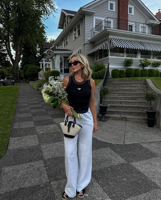Black Sleeveless Top With White Wide Leg Trousers And Floral Accent