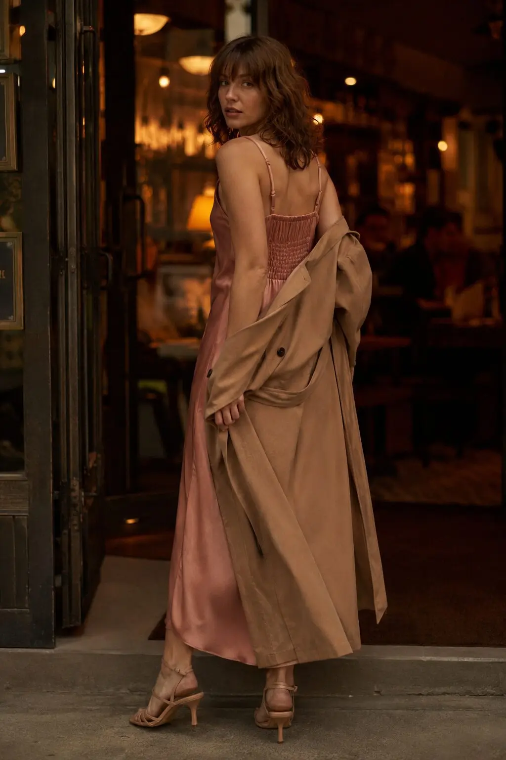 trench coat outfit for evening: camel trench coat over a silk slip dress with black strappy heels