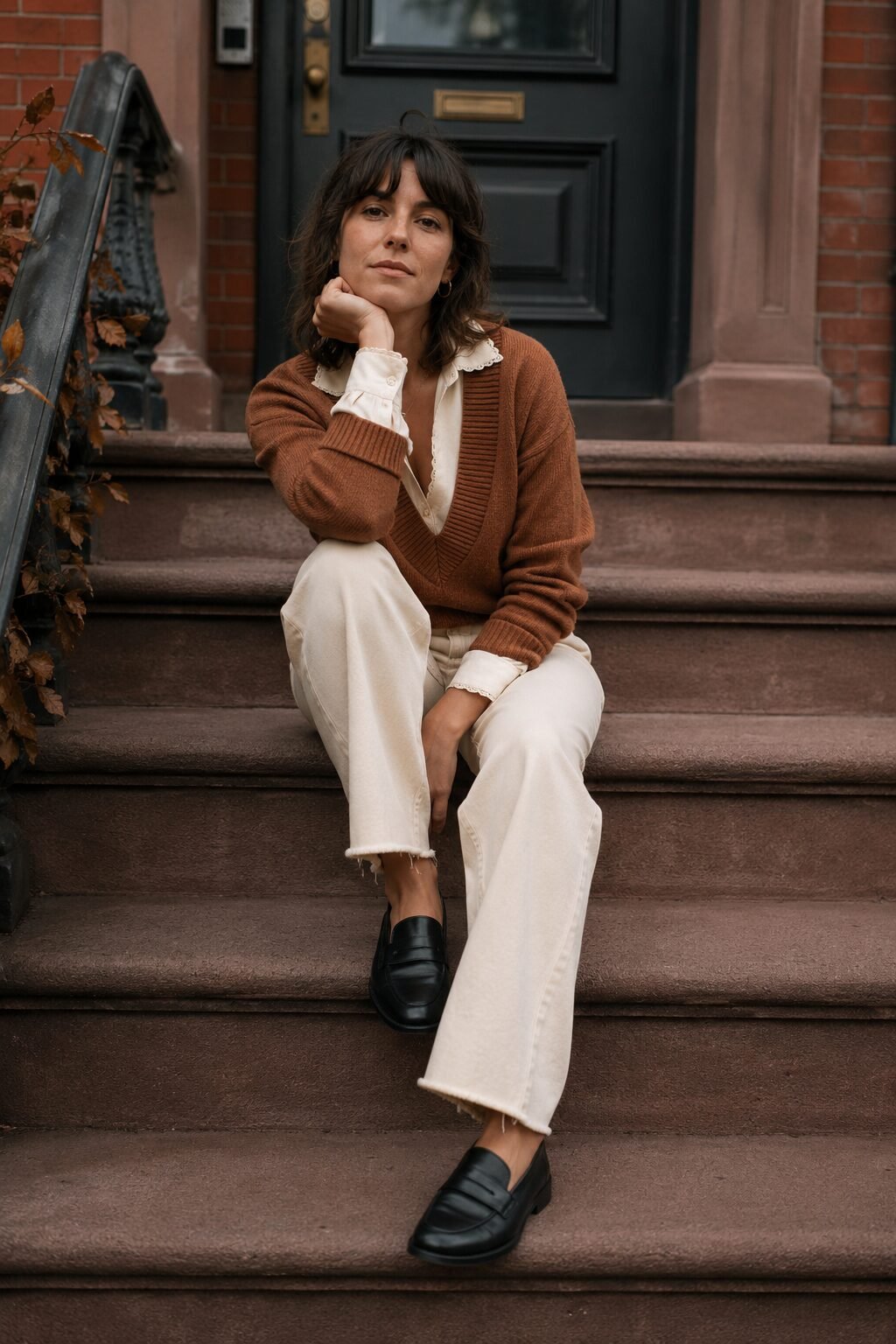 how to style a sweater with a collared shirt: v-neck sweater layered over an ecru button-down shirt with black loafers