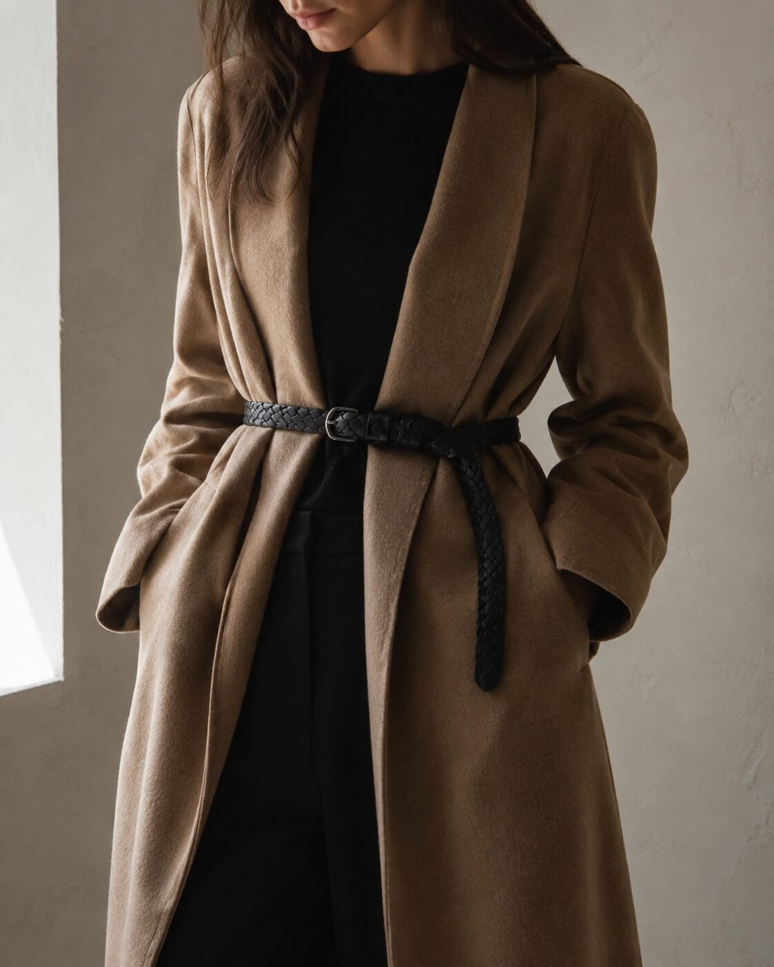 affordable quiet luxury fall outfit: camel wool coat cinched at the waist with a braided black leather belt