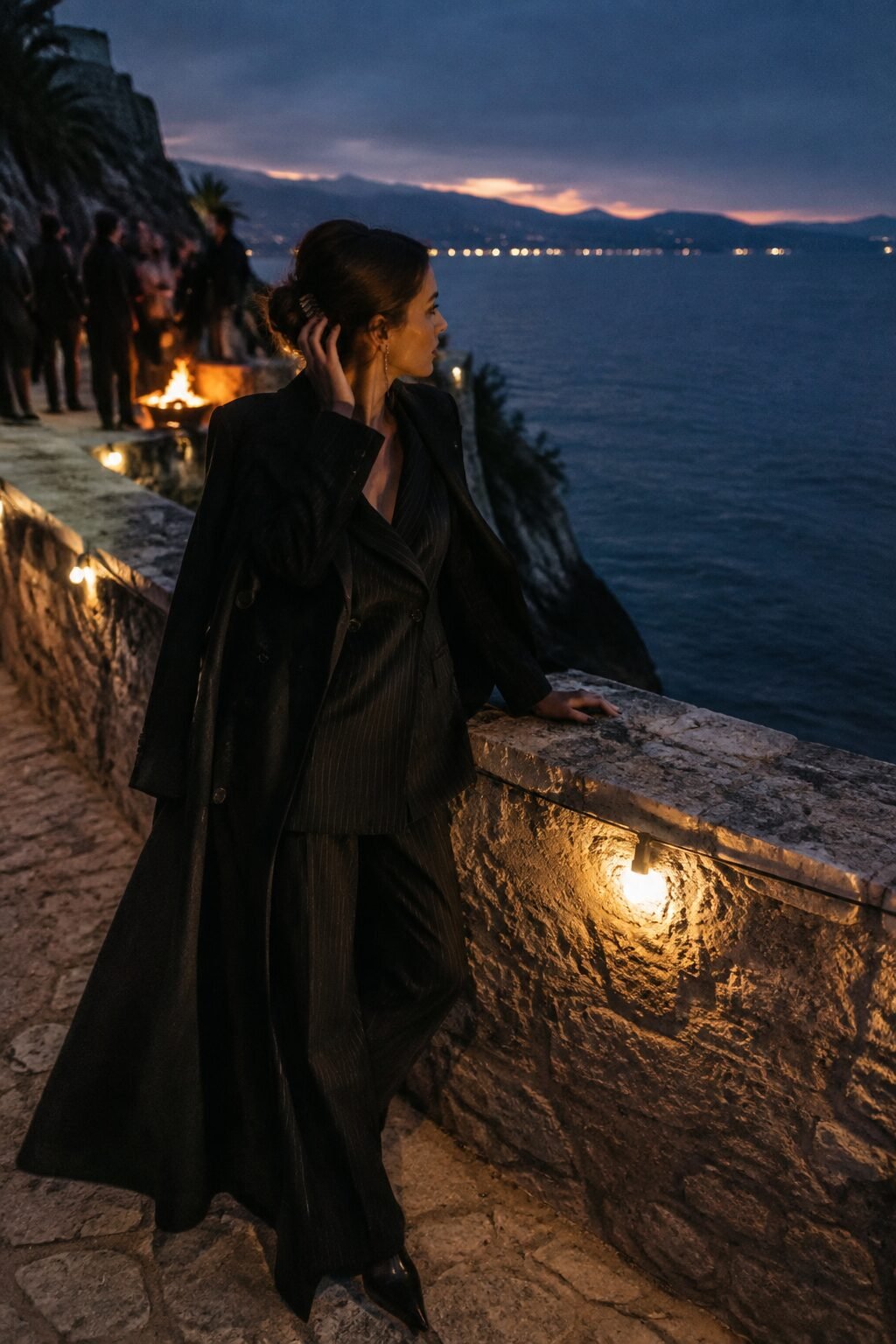 witchy outfits for fall evening look: dramatic black wool coat over pinstripe trouser set