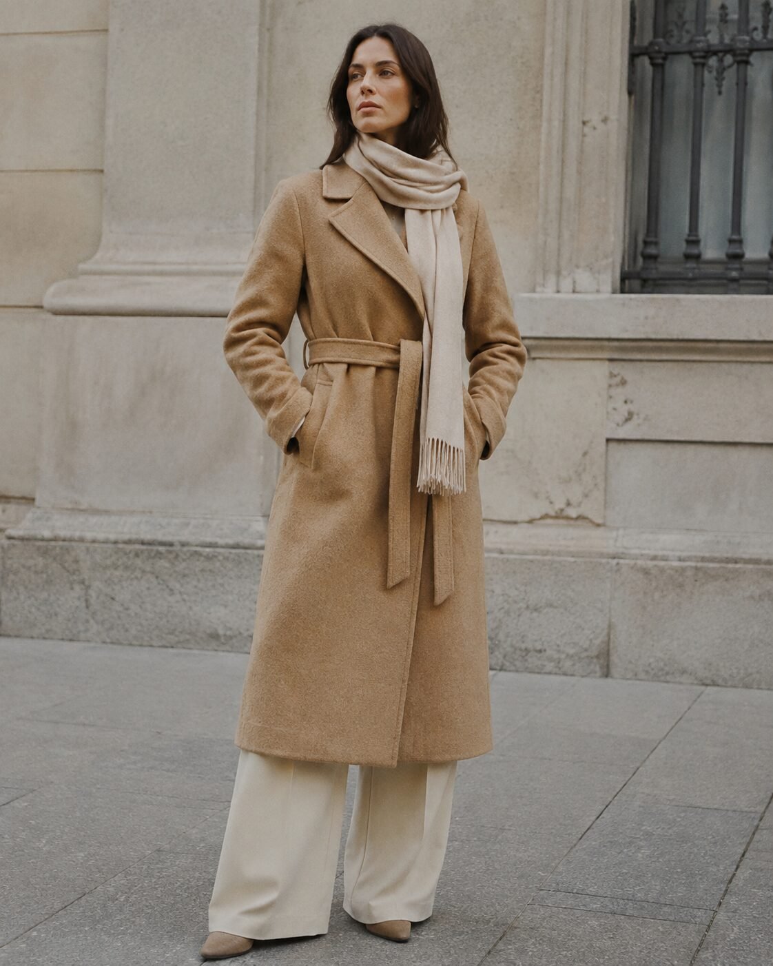 affordable quiet luxury fall outfit: camel wool coat with an oatmeal cashmere scarf draped simply around the neck