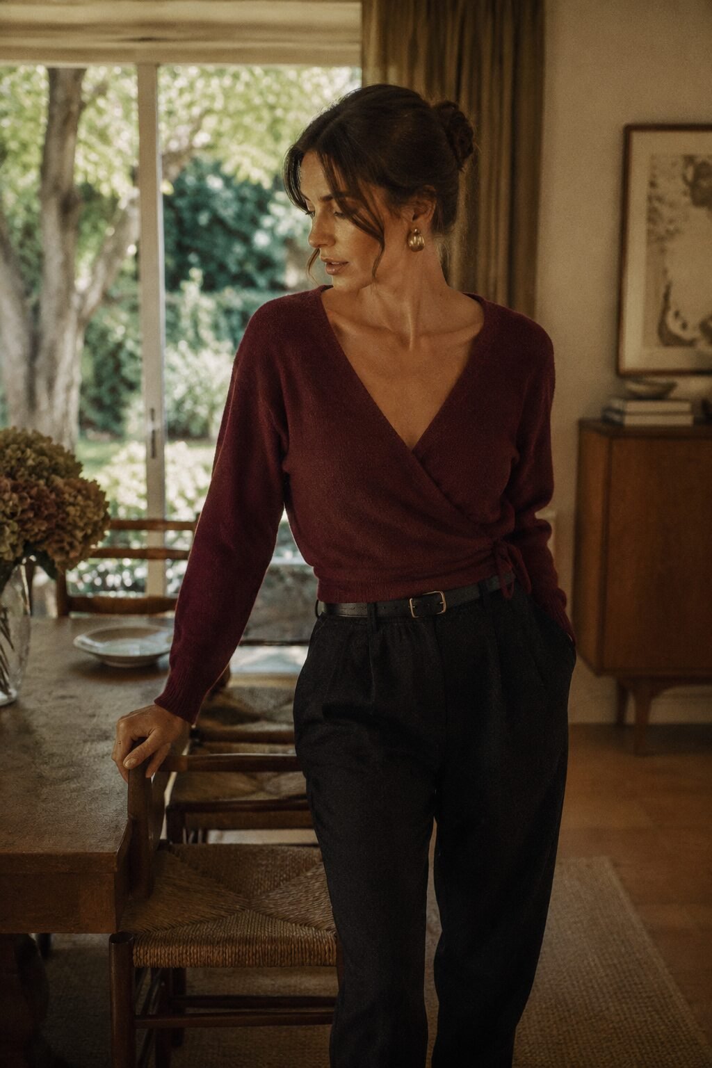 fall capsule wardrobe outfit idea: burgundy wrap sweater and black trousers for a Sunday family dinner