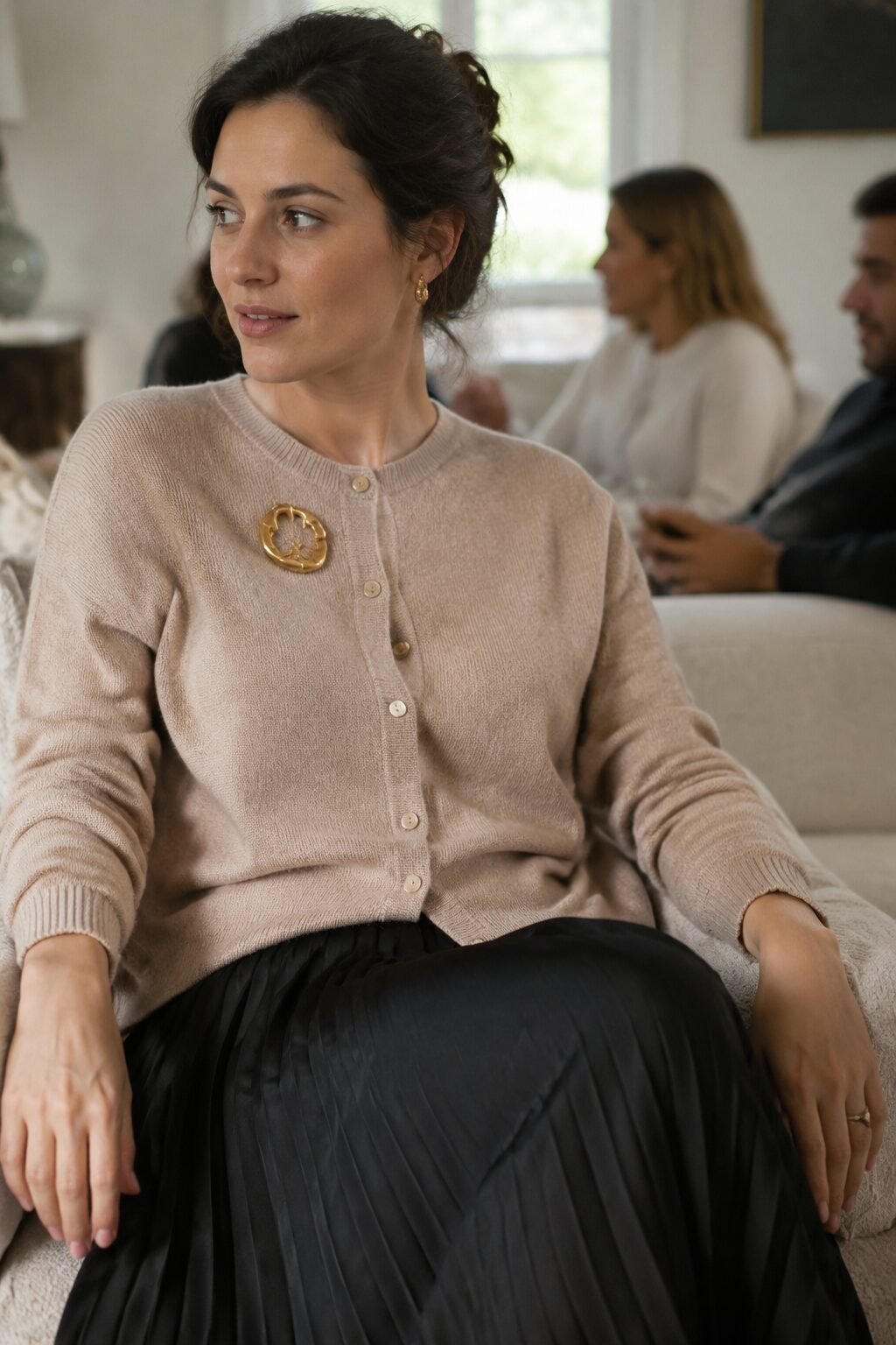 wheat cashmere cardigan pinned with a statement brooch over a black silk pleated skirt, a casual family gathering christmas outfit