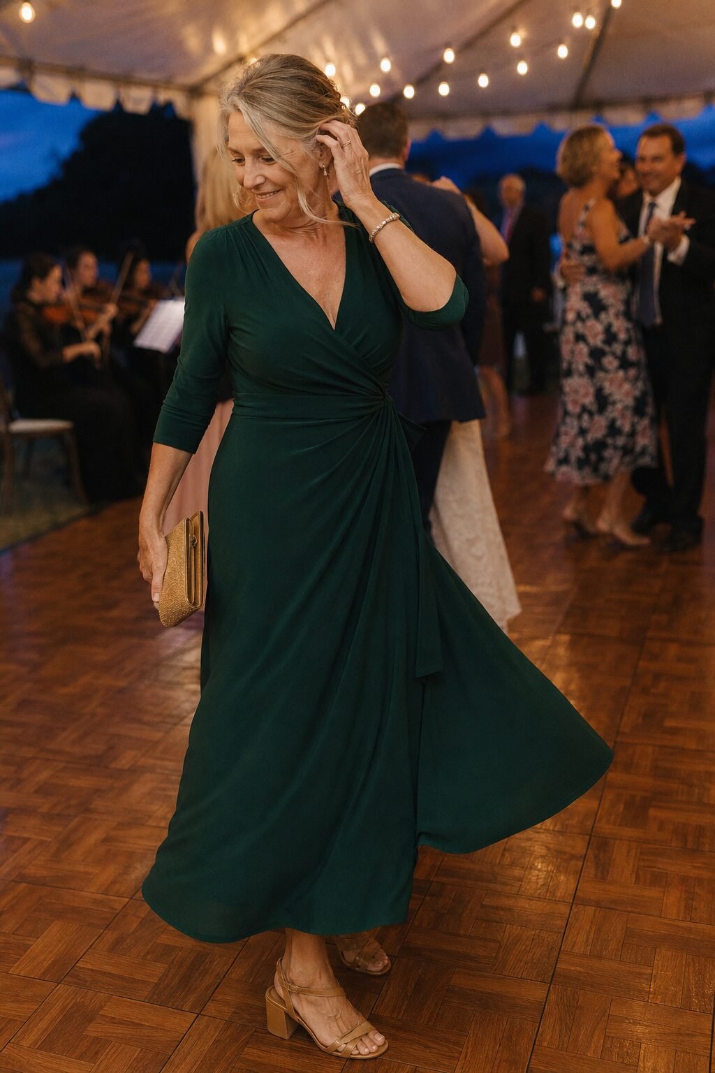 mother of the groom reception dance outfit: evergreen wrap dress worn alone with gold clutch and amber sandals