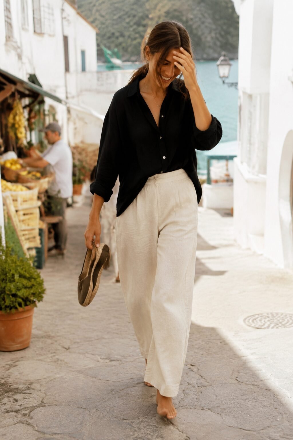 Woman in a black linen shirt on a sunlit Italian street