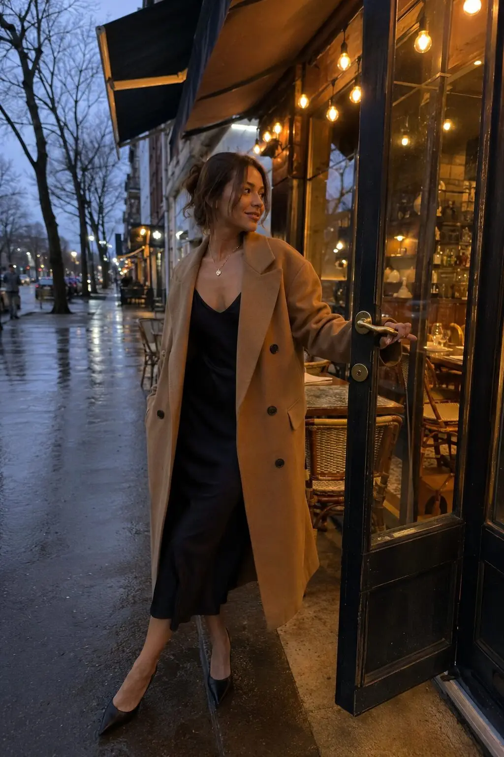 camel wool coat worn open over a black slip dress for dinner out
