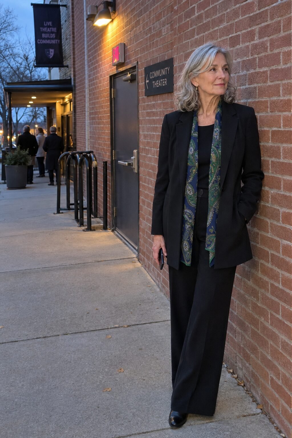 how to style a silk scarf draped flat under a long black blazer with black wide-leg pants for a theater evening