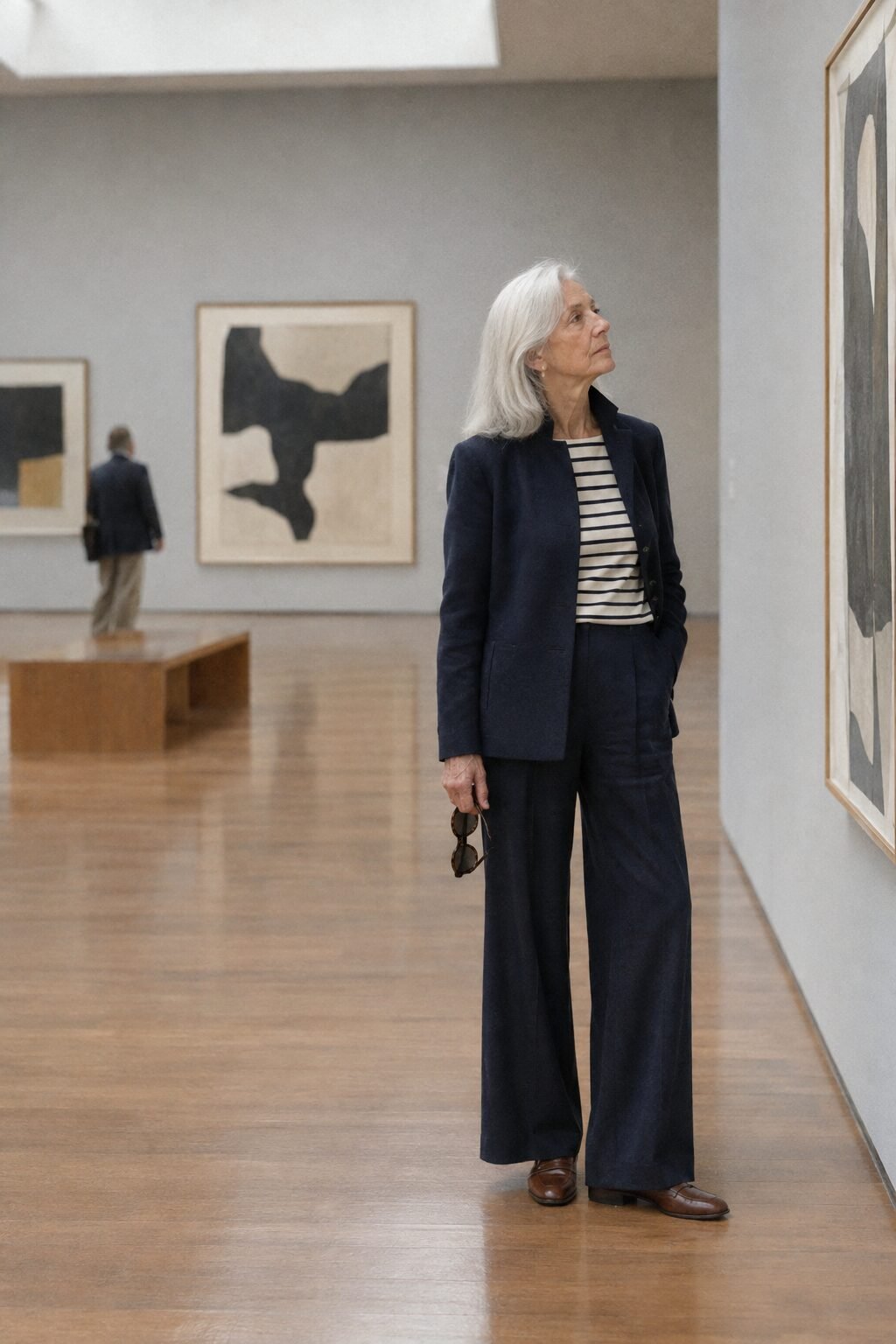 navy tonal outfit for women in their 70s: silk wide-leg pants, striped boatneck top, navy wool blazer and brown almond loafers for a gallery visit