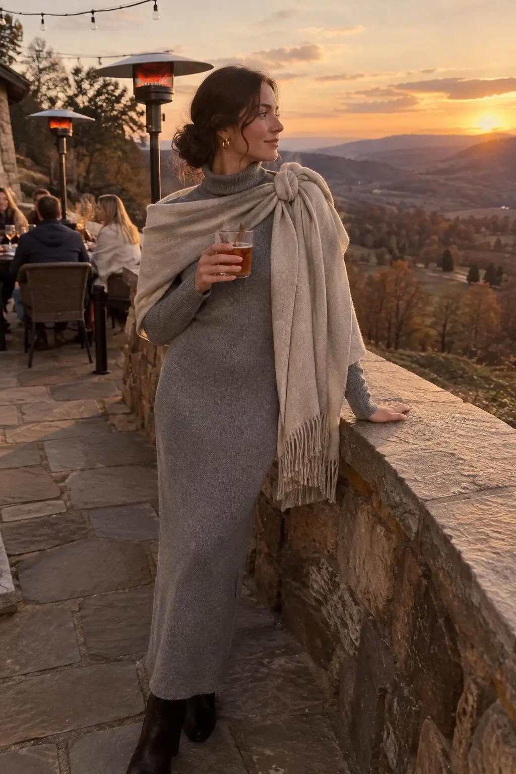 woman wearing a heather grey long-sleeve sheath dress with an oatmeal cashmere wrap knotted at one shoulder for an outdoor fall wedding cocktail hour