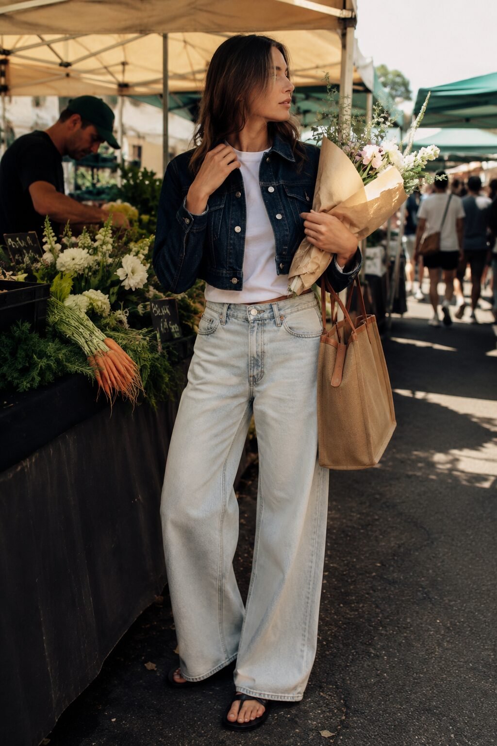 woman wearing a dark indigo cropped denim jacket with bleached wide-leg jeans and a white tee for a weekend outfit