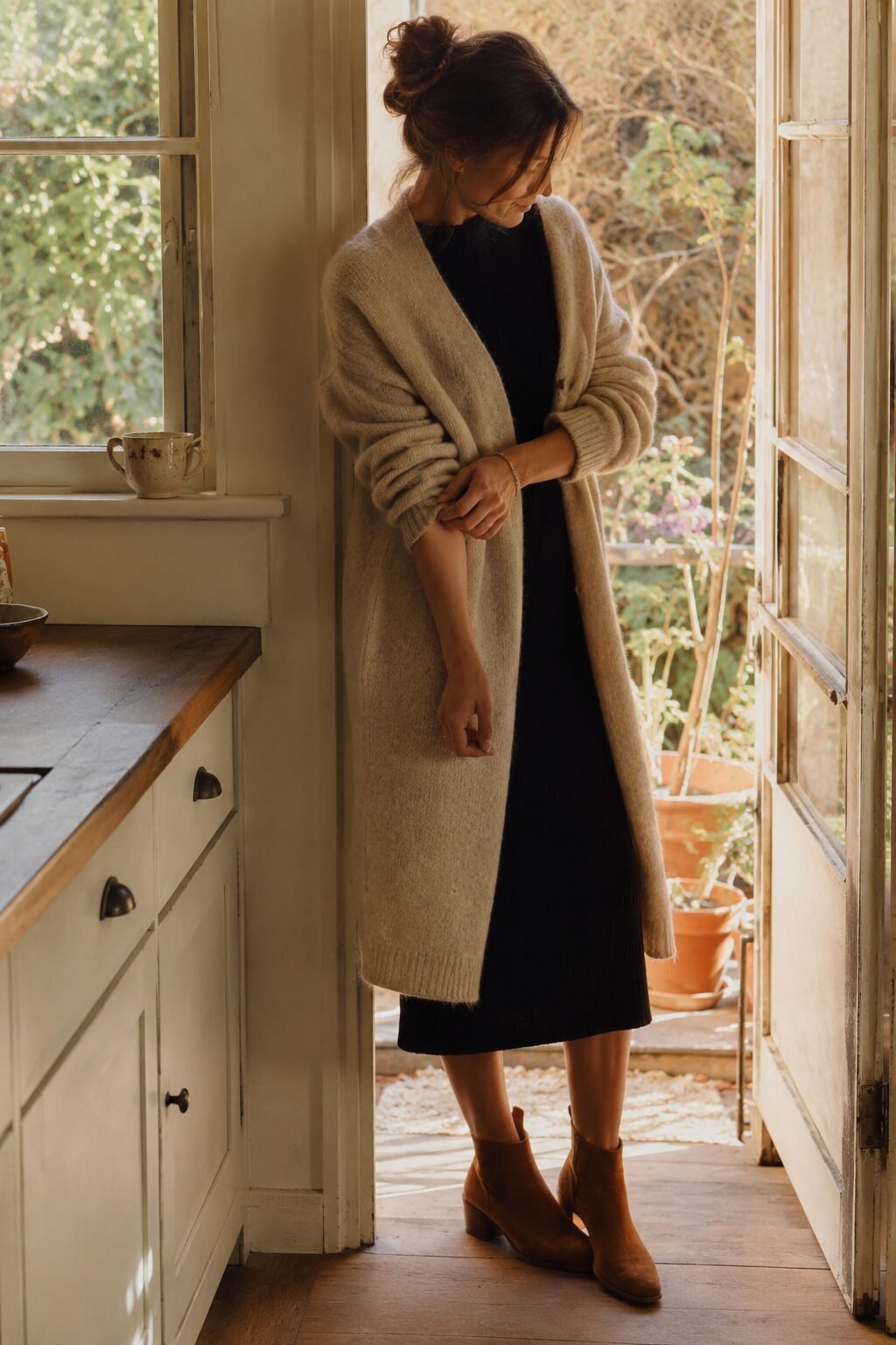 black midi dress layered with an oversized oatmeal cardigan and ankle boots