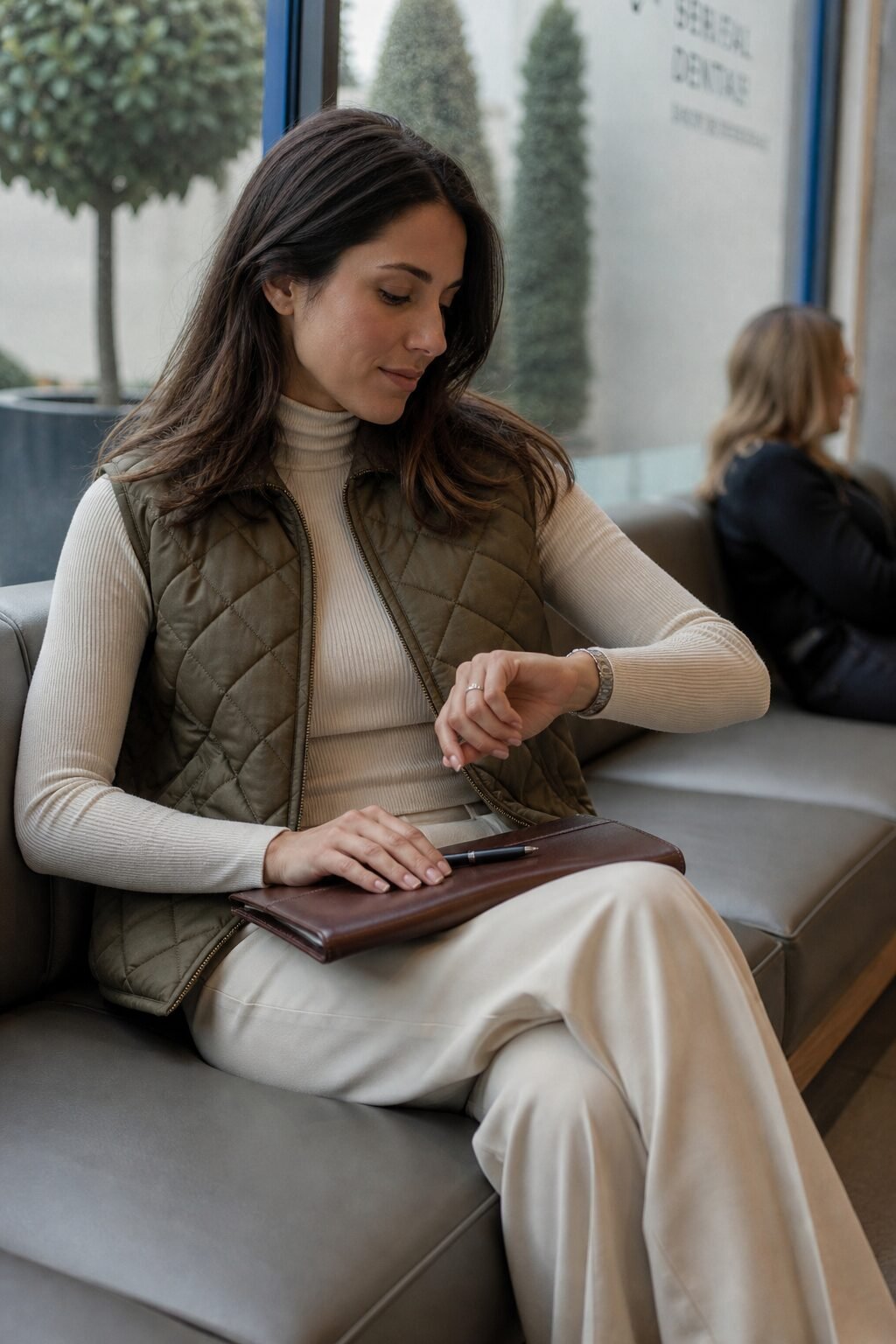 comfortable elevated errand outfit: olive quilted vest, cream turtleneck, and tailored trousers
