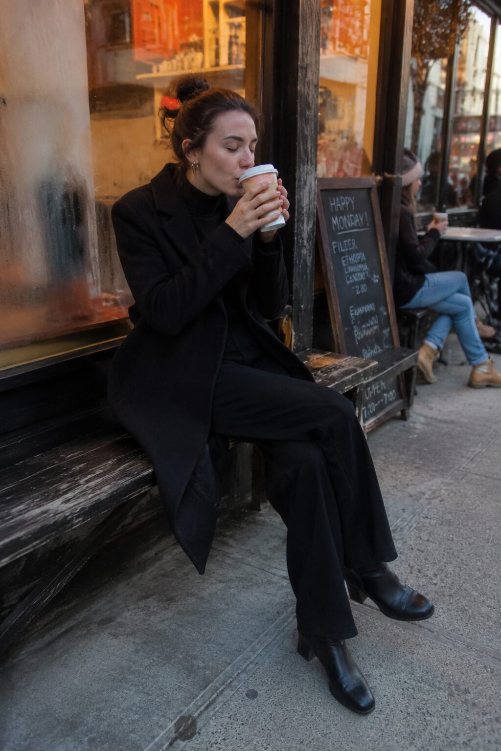 cozy fall coffee run outfit from a black capsule wardrobe: cashmere turtleneck, wide-leg trousers, wool coat, ankle boots
