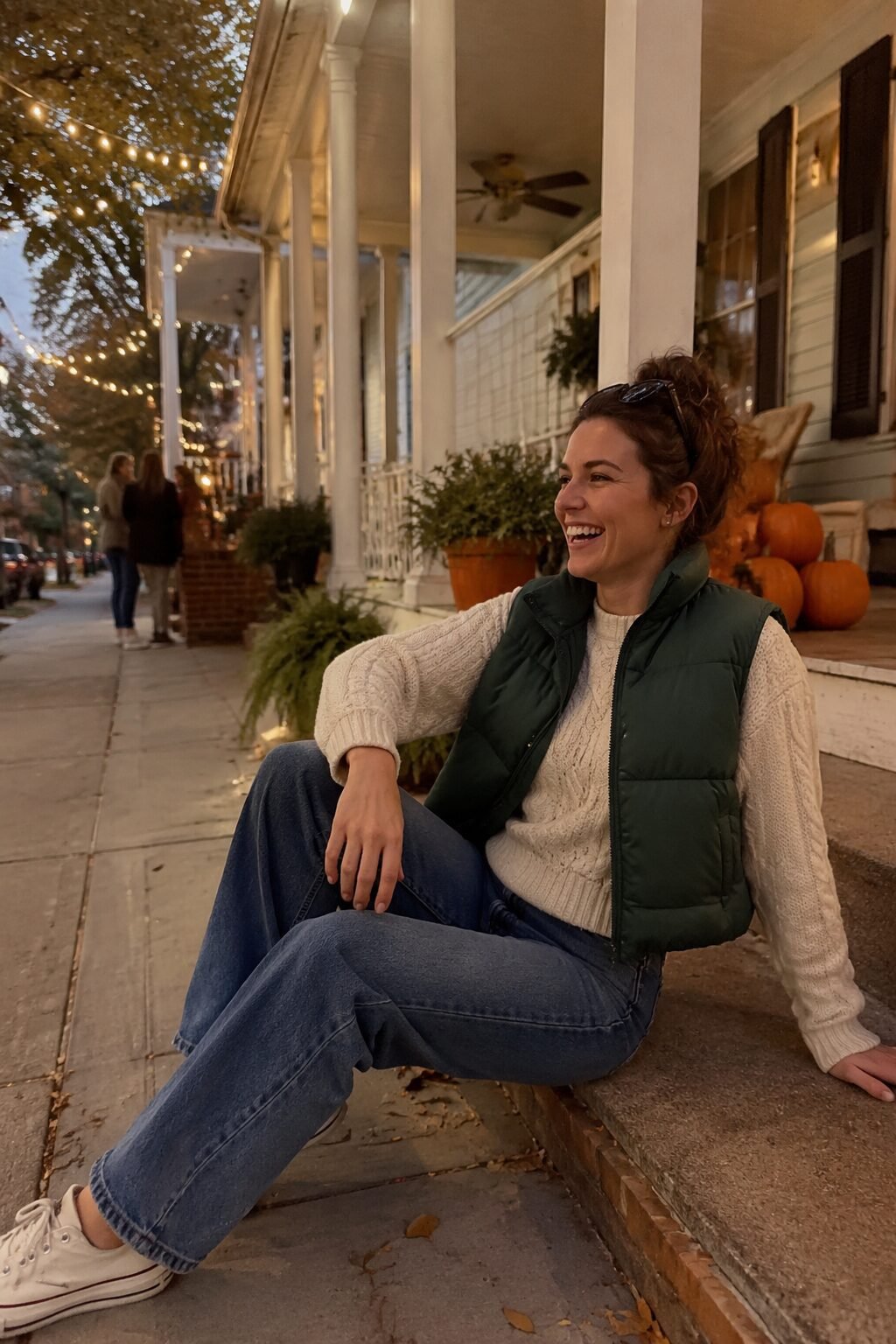 forest green puffer vest over a cream cable knit sweater and straight jeans, mild-weather halloween outfit for moms trick-or-treating