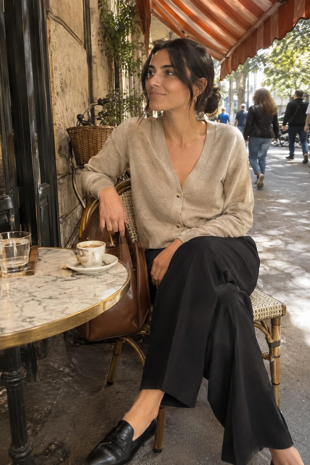 7 piece capsule wardrobe outfit: oatmeal cashmere cardigan with black wide-leg trousers, black loafers, and a saddle tote bag