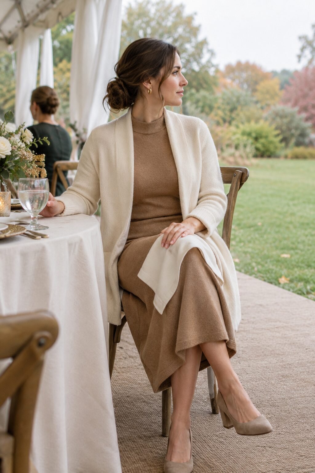 woman wearing a camel long-sleeve mockneck sheath dress with an open ivory structured cashmere cardigan for a daytime fall wedding reception