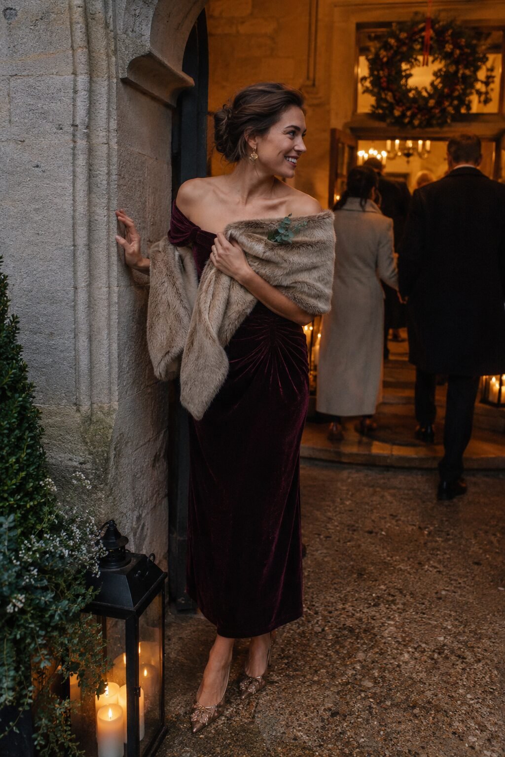 old money wedding guest dress: burgundy velvet bardot dress with a faux fur scarf and gold earrings for a formal winter wedding