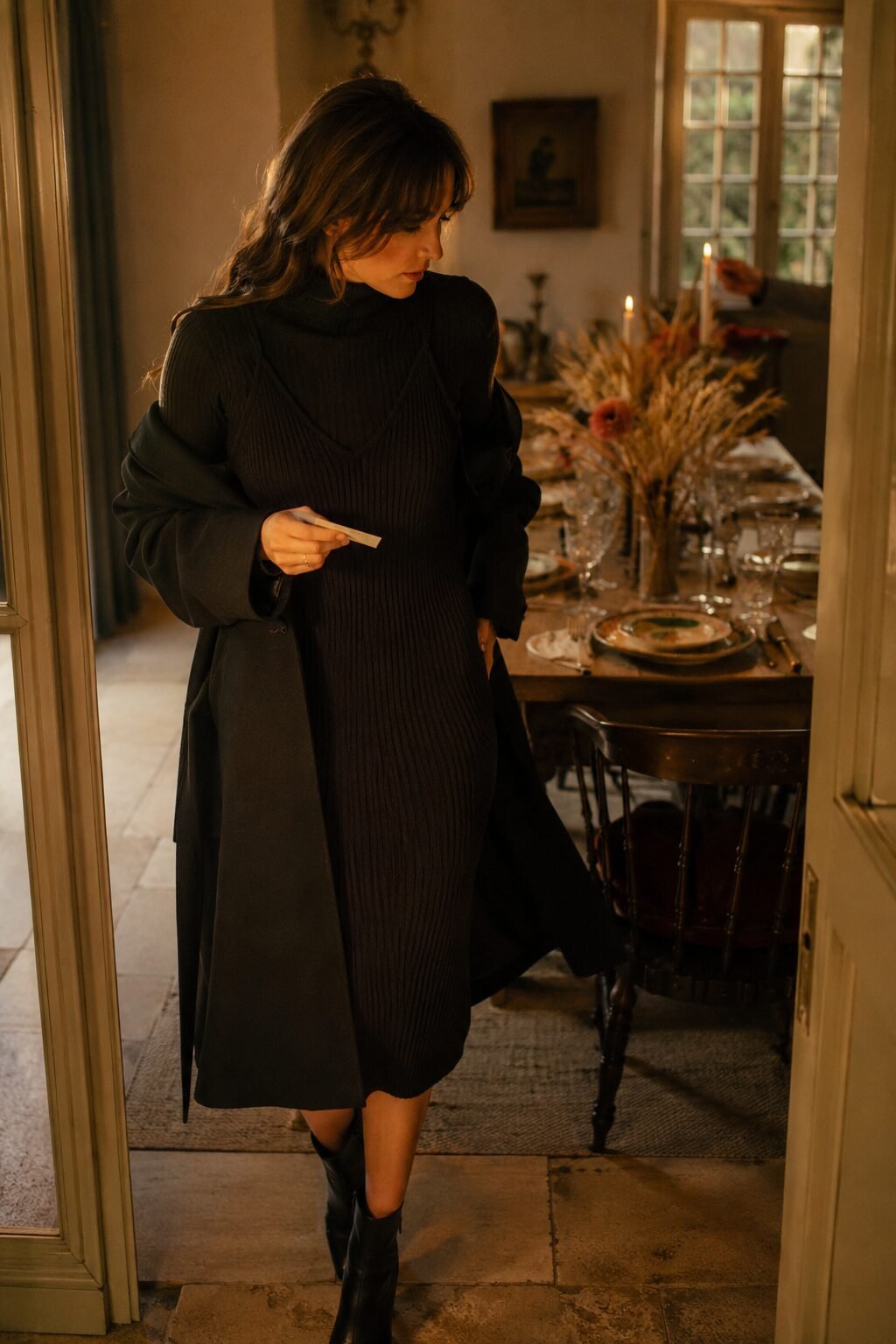 Thanksgiving outfit from a black capsule wardrobe: knit midi dress layered over a cashmere turtleneck, wool coat, ankle boots
