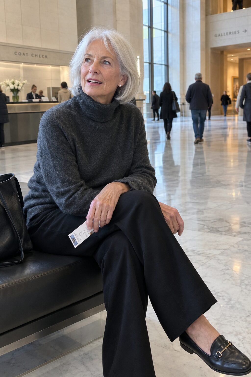 warm museum outfit for a woman in her 70s: charcoal cashmere turtleneck with black wide-leg wool trousers