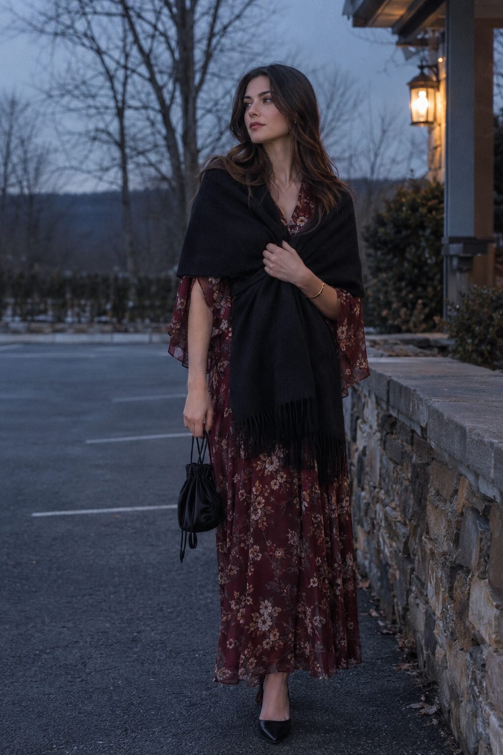 wedding guest outfit with gold bracelet: burgundy floral capelet-sleeve maxi dress and black cashmere wrap for a winter wedding