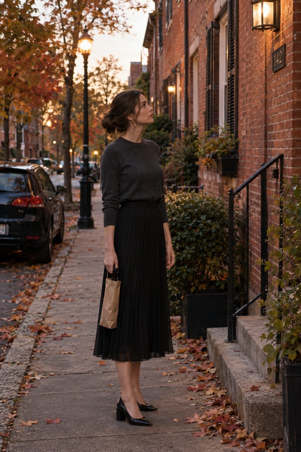 old money dinner outfit for women: dark gray merino sweater, black pleated chiffon midi skirt and black block-heel pumps