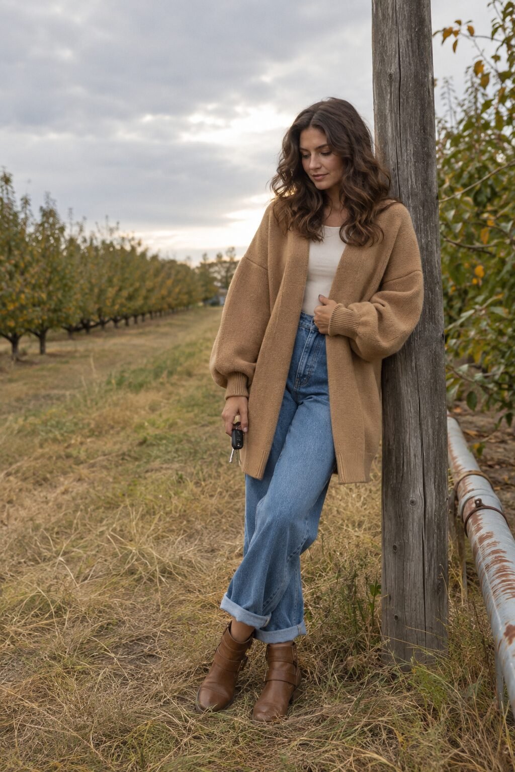 cozy apple picking outfit: camel oversized cardigan, medium wash wide-leg jeans and cognac ankle boots