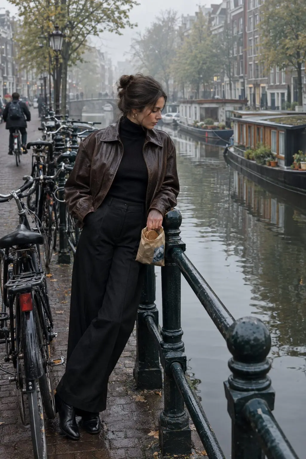 european fall outfit: chocolate leather bomber jacket over a black cashmere turtleneck and wide-leg trouser