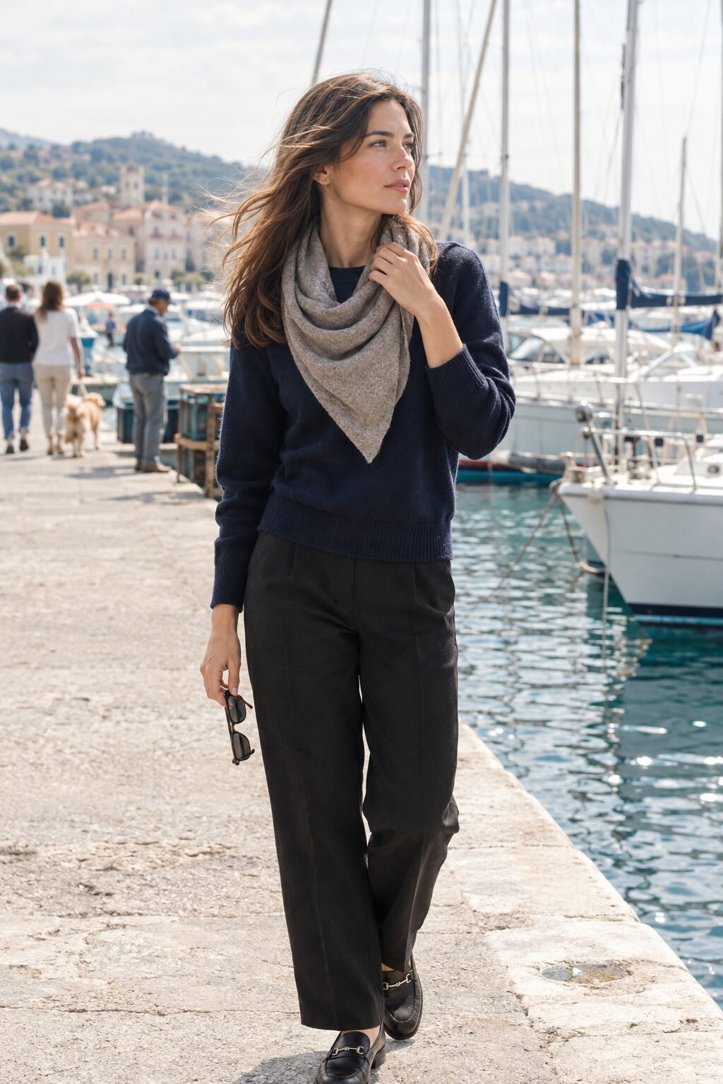 woman adjusting a taupe cashmere scarf around her neck outdoors