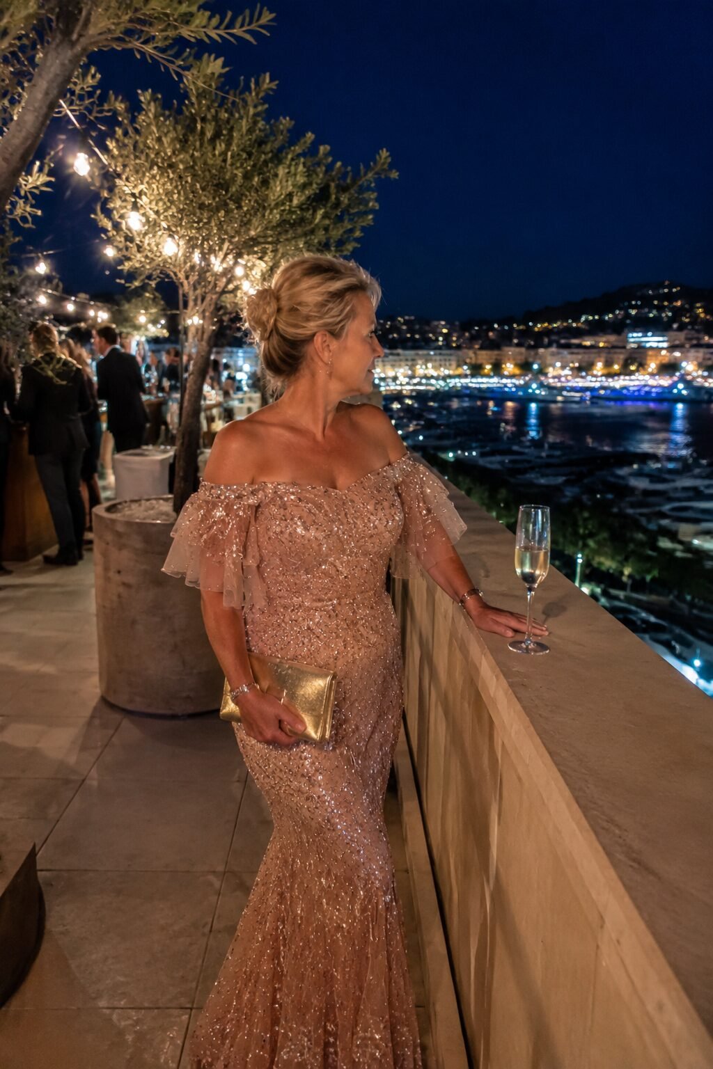 rose gold metallic mermaid gown with a matching gold clutch for a black-tie mother of the groom outfit