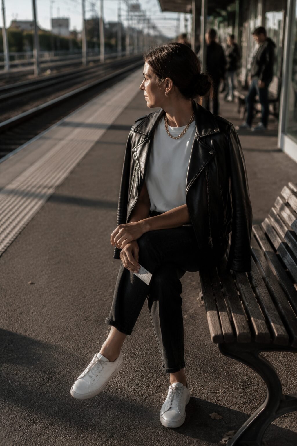 how to style a black leather jacket with statement gold jewelry over a simple tee and jeans base