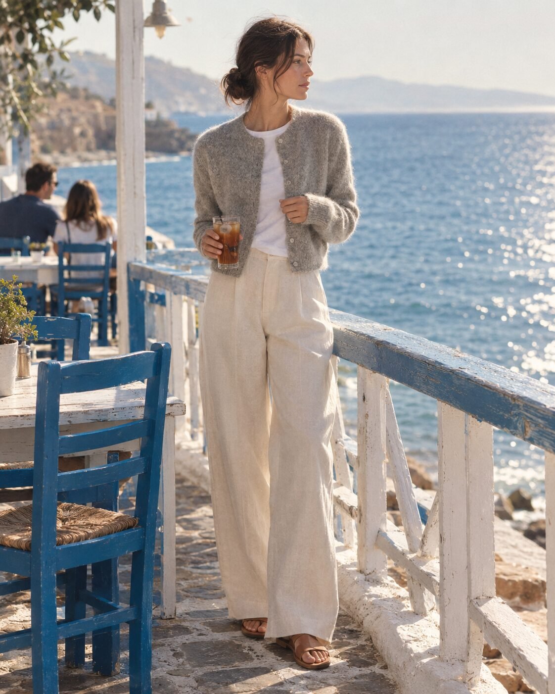 woman in a soft neutral cardigan over a white tee and relaxed trousers, dressed one step above casual