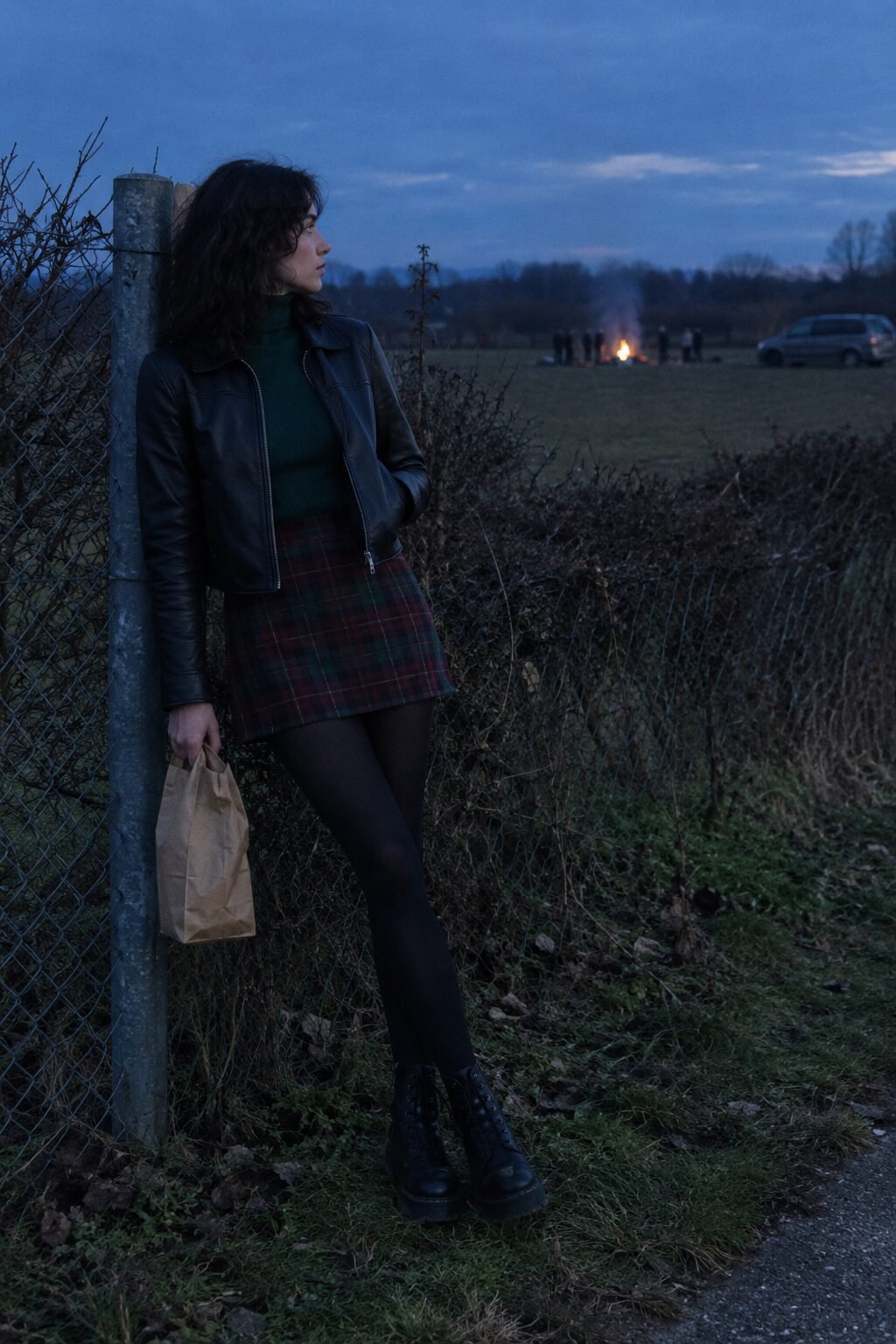 woman in a black leather jacket, dark green turtleneck, tartan mini skirt over black tights and combat boots, witchy Halloween outfit