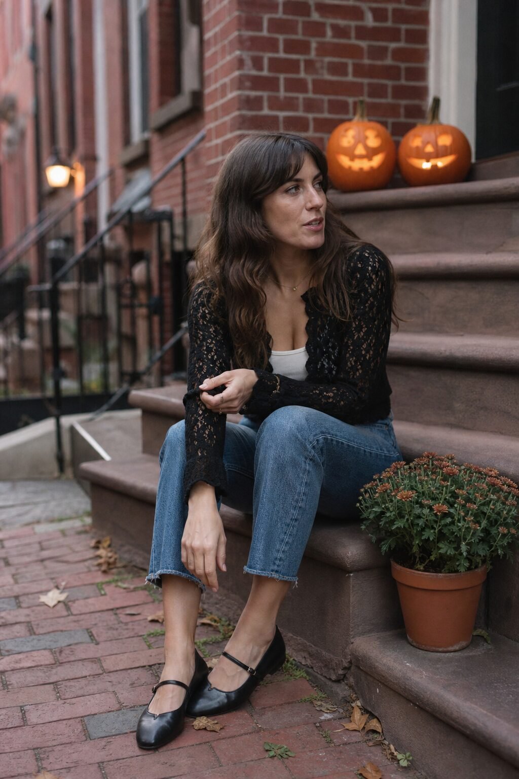 casual halloween party outfit: black lace-trim blouse layered over straight-leg denim