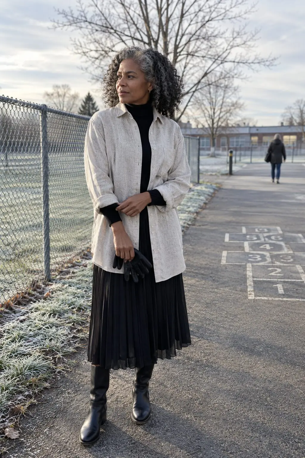 how to style a linen shirt worn open over a black ribbed turtleneck with a black chiffon pleated midi skirt
