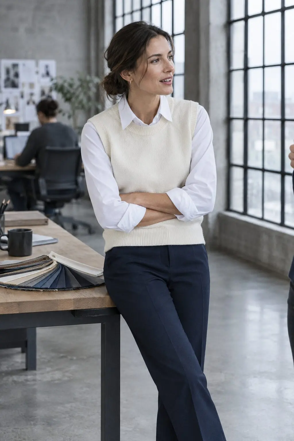 european street style fall outfit: ivory sweater vest over a white shirt and navy trousers