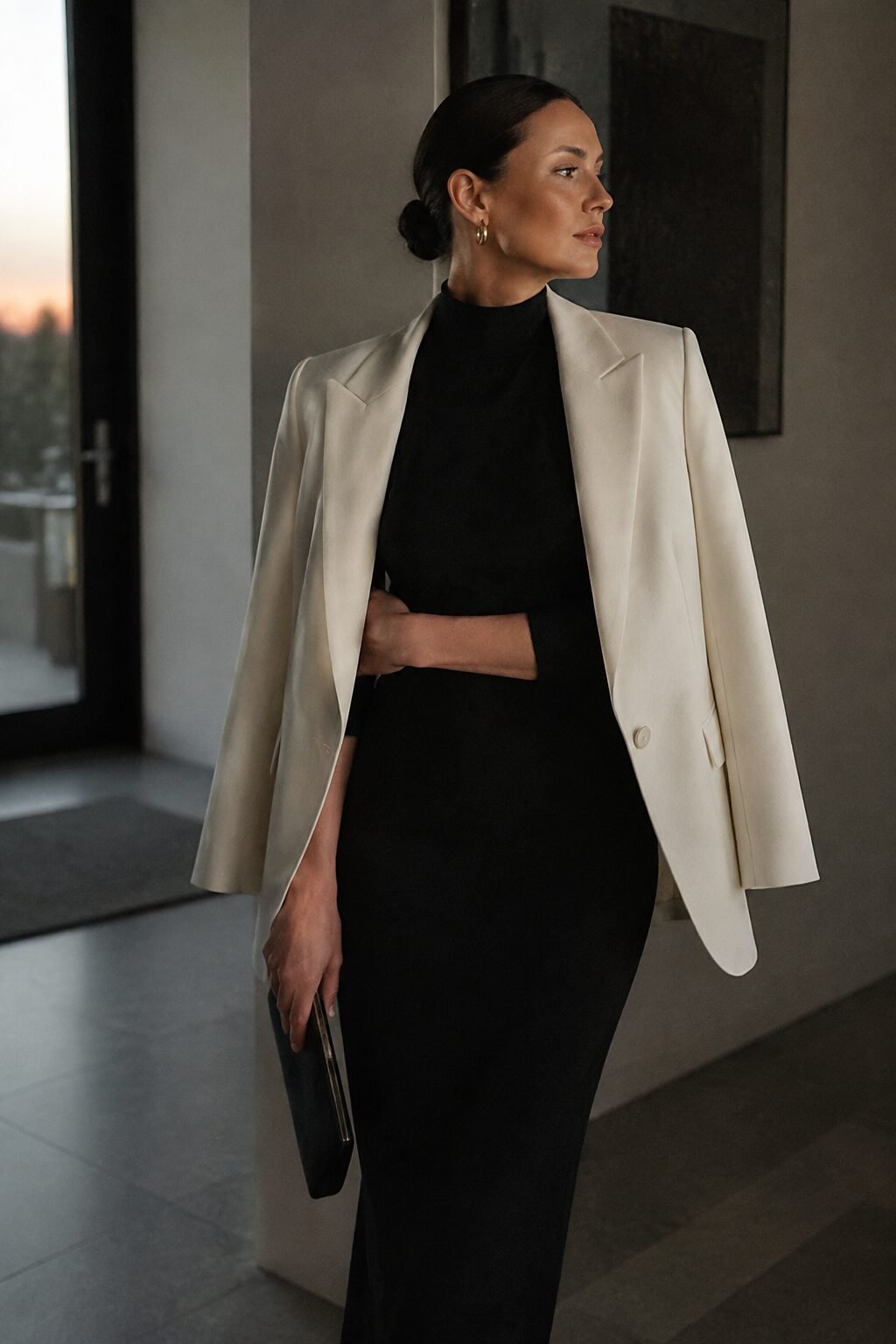 evening black high-neck sheath dress outfit with an ivory blazer draped over the shoulders