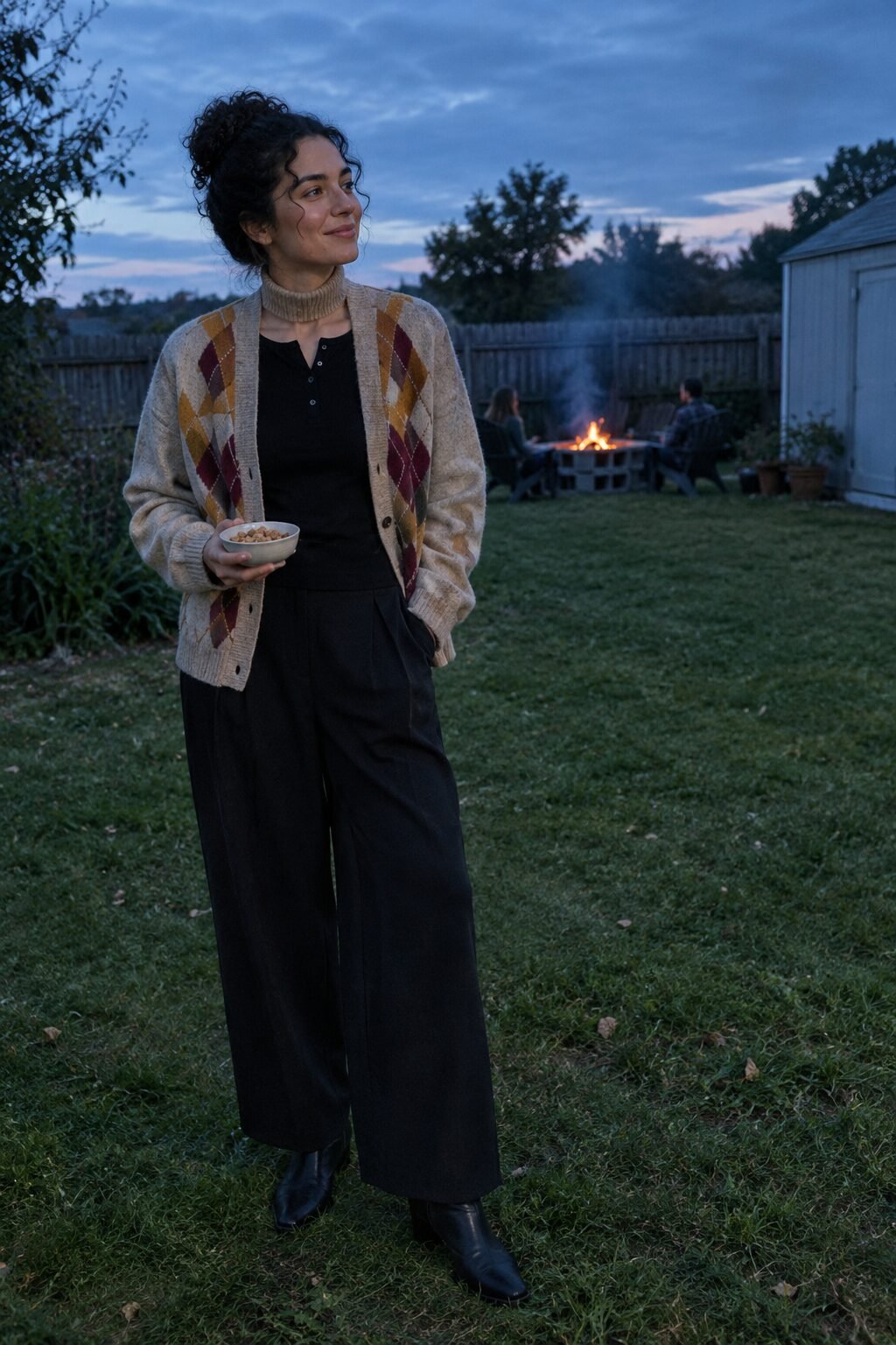 woman in an oat argyle cardigan with mustard and burgundy diamonds, black waffle henley and black wide-leg trousers, Halloween night outfit