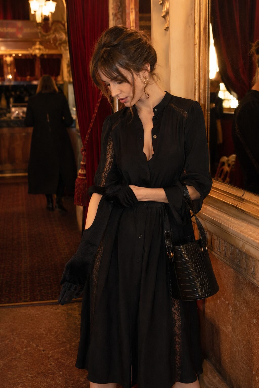 elegant Halloween outfit: lace-detail black midi dress with a crocodile-print bucket bag