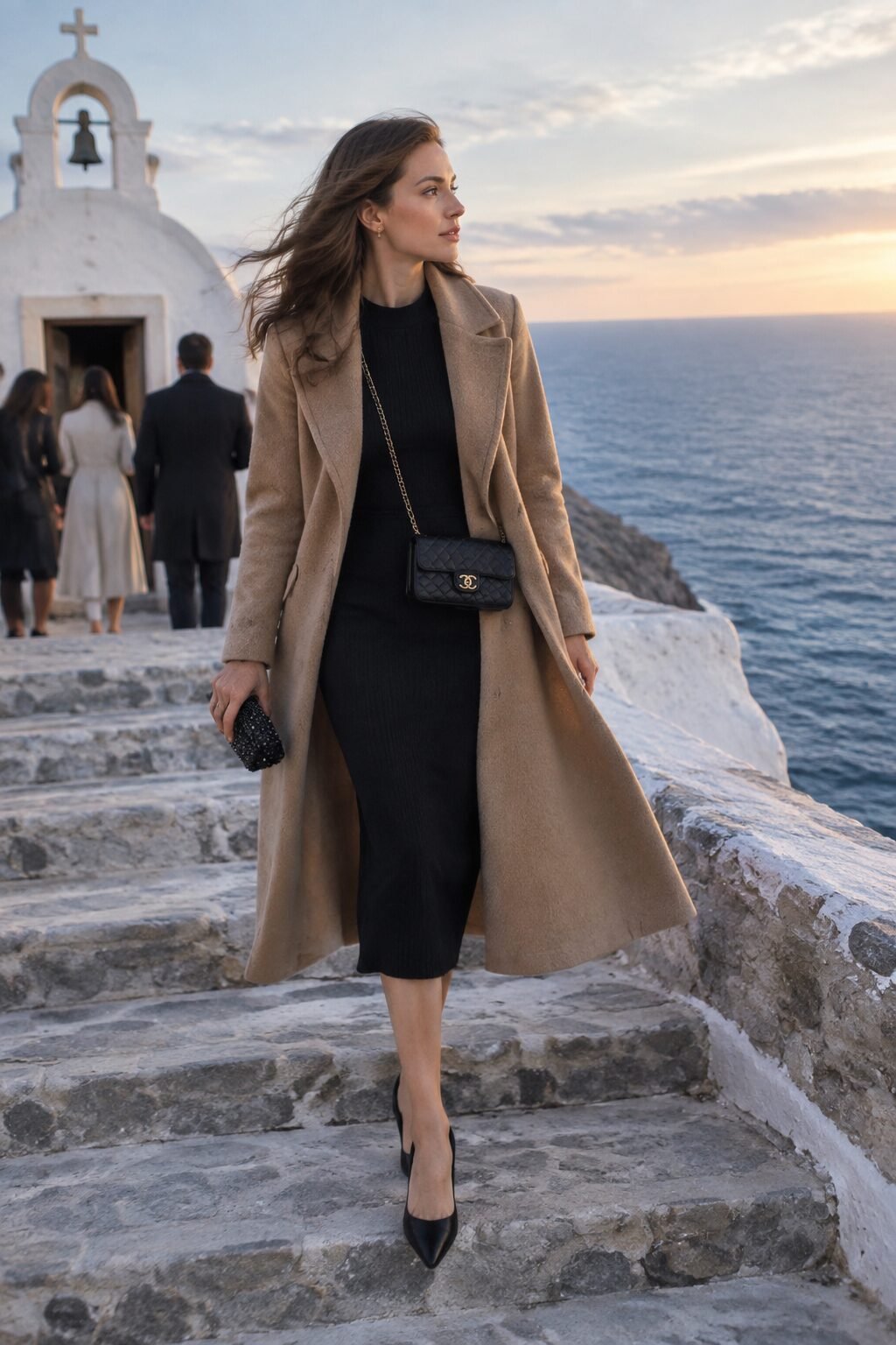 old money winter wedding guest outfit: black knit dress and camel wool wrap coat
