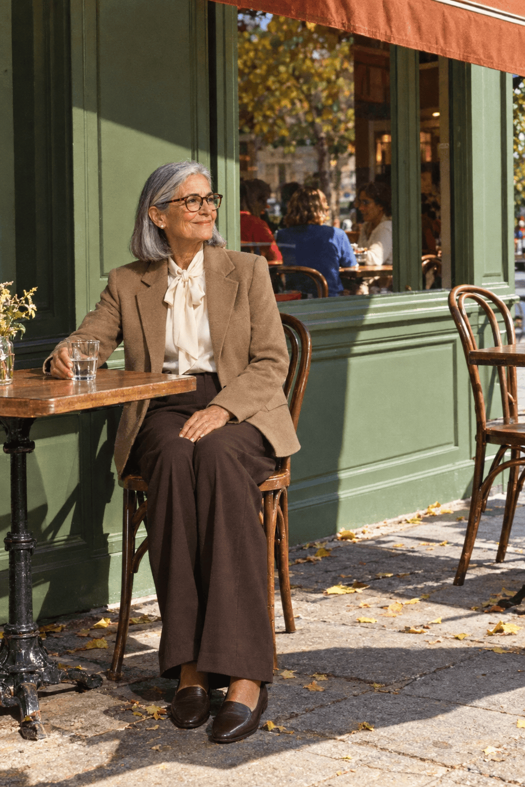 ladies who lunch outfit for women in their 70s: hip-length camel wool blazer, ivory silk bow blouse, chocolate wide-leg trousers and chocolate loafers