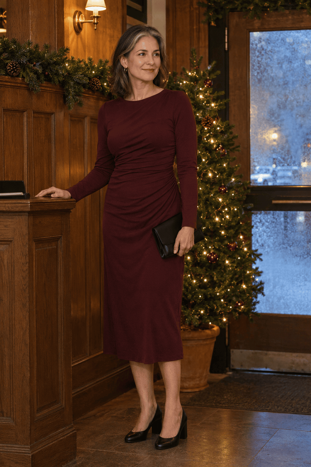 elegant christmas dinner outfit for women over 50: long-sleeve burgundy jersey midi dress with black block-heel pumps and satin clutch