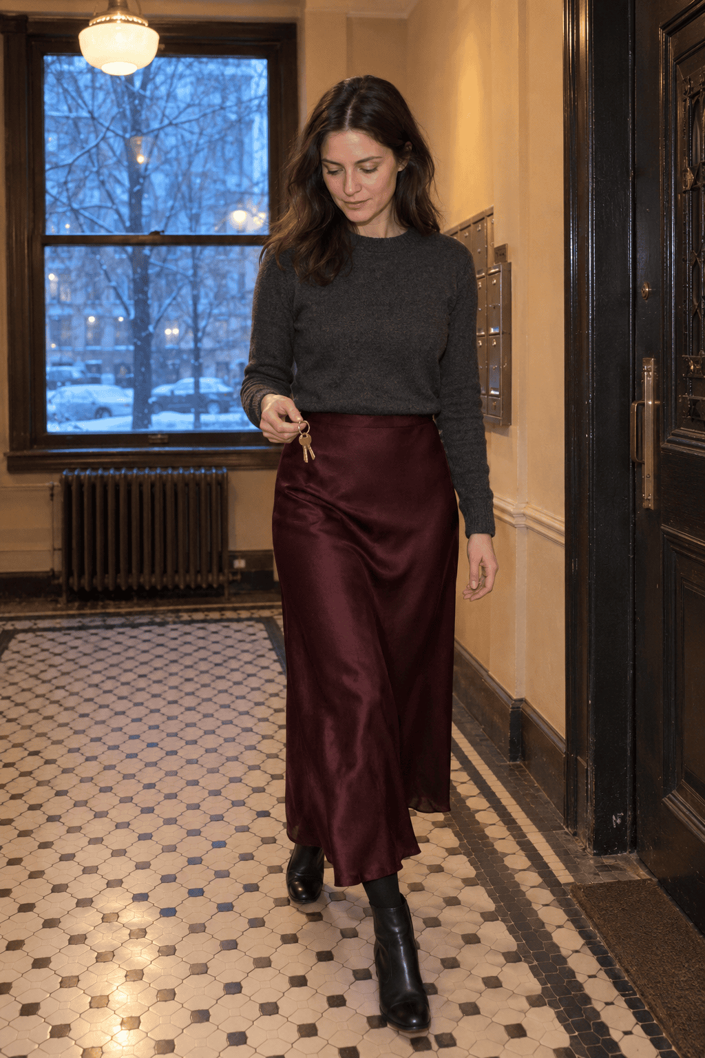 long skirt winter outfit for dinner: oxblood silk bias-cut maxi skirt with a charcoal cashmere crewneck and black leather block-heel ankle boots